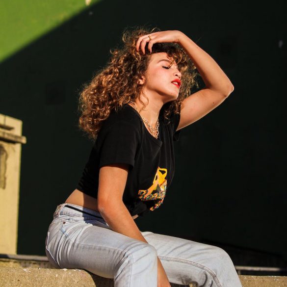woman in black crew neck t shirt sitting on stairs with her hand on her hair